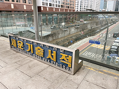 Jongmyo, mascot AH-BOT, and a retro-style bench overlooking Cheonggyecheon stream from the 3rd floor of Sewoon Plaza