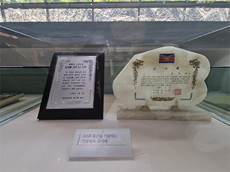 A plaque commemorating the 100th printing of the book and some of Jo Jung-Rae’s signature collectibles he used during his writing